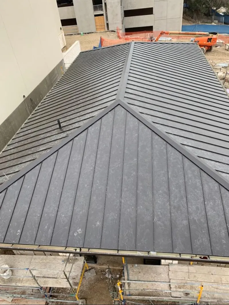 Commercial metal roof construction with crane equipment in Murphy